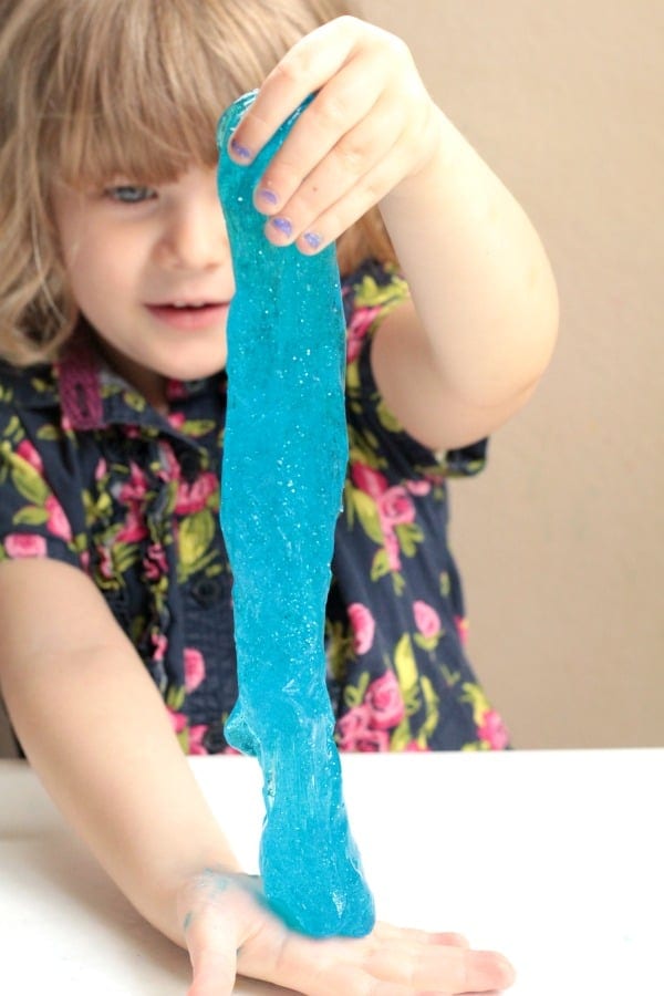Little girl stretching ocean slime made with borax.