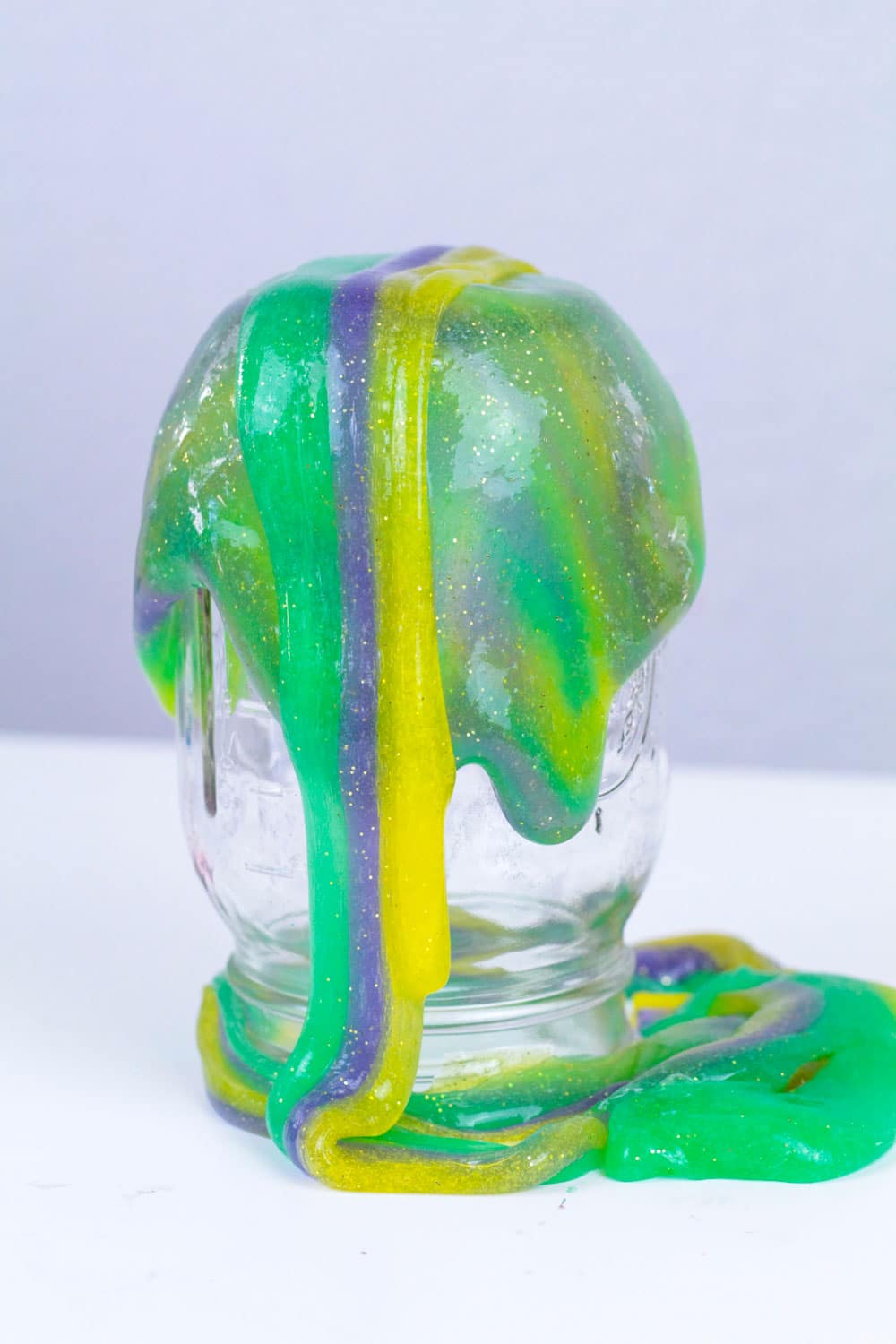 Holiday slime recipes are so much fun! This Mardi Gras slime recipe is the perfect slime recipe for Mardi Gras! The simple slime recipe is so colorful and stretchy, it's the perfect Mardi Gras activity for kids!