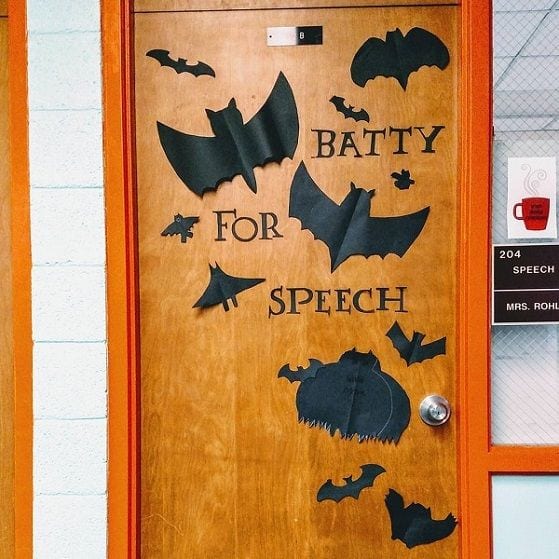 A halloween classroom door that has pictures of bats that says "batty for speech"