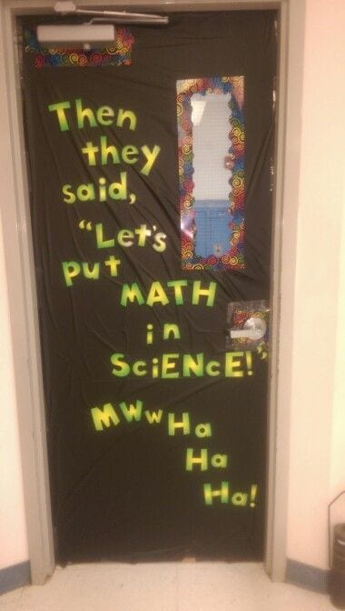 A halloween door decoration that is covered in black paper and says "then they said let's put math in science! Mwwhahhaha!"